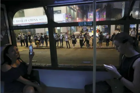  ?? KIN CHEUNG — THE ASSOCIATED PRESS ?? Demonstrat­ors, seen from inside a tram, link hands along a street in Hong Kong, Friday.