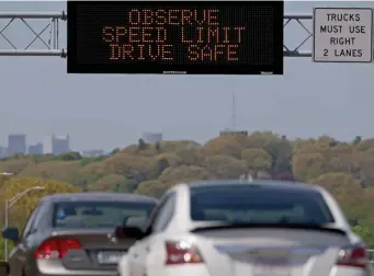  ?? MATT sTonE pHoTos / HErAld sTAFF ?? WARNING SIGN: Cars go speeding by on I-93 North in Quincy on Tuesday as a sign warns against speeding.