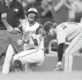  ?? JOHN BAZEMORE/AP ?? The Braves’ Ronald Acuna Jr. (13) reacts after sliding into third base with a triple as Marlins third baseman Brian Anderson handles a late throw in the third inning of Monday’s game.
