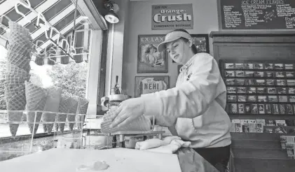  ?? GARY C. KLEIN/USA TODAY NETWORK-WISCONSIN ?? Gessert’s Ice Cream and Confection­ery employee Taylor Coenen makes cones by hand at the store in Elkhart Lake.