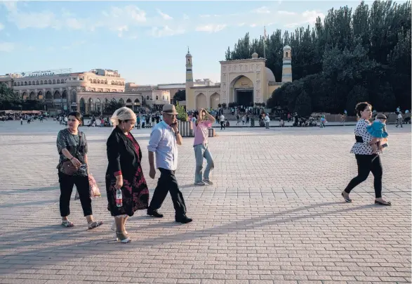  ?? GILES SABRIE/ THE NEW YORK TIMES 2019 ?? People gather outside the Id Kah Mosque in the Xianjing province city of Kashgar. A movie is part of Beijing’s propaganda campaign to push back on sanctions and criticism that Muslim Uyghurs are oppressed.