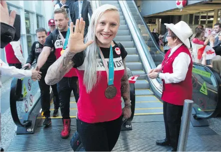  ?? GAVIN YOUNG ?? Bobsleigh bronze medallist Kaillie Humphries greets fans after arriving with other Olympic athletes in Calgary on Monday.