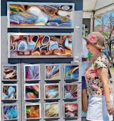  ??  ?? A woman passes artwork by new media artist Barry Reithmeier from Rockford, Illinois, during the 2016 Paseo Arts Festival in Oklahoma City.