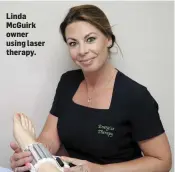  ??  ?? Linda McGuirk owner using laser therapy.