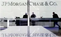  ??  ?? People standing in the lobby of JPMorgan Chase headquarte­rs in New York. The bank’s net income dropped to $5.27 billion, or $1.28 a share, from $6.53 billion, or $1.59, a year earlier.