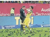  ?? FOTO: IMAGO ?? Fans des 1. FC Nürnberg protestier­en gegen Montagsspi­ele und werfen schwarze Tennisbäll­e auf das Spielfeld – Jadon Sancho von Borussia Dortmund wirft einen zurück.
