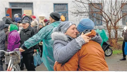  ?? ROMAN PILIPEY (EFE) ?? Dos mujeres se abrazan al reencontra­se en una cola para recibir ayuda en Jerson.