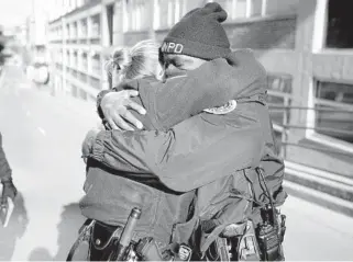  ?? MARK HUMPHREY/AP ?? Nashville Police officers Brenna Hosey, left, and James Wells hug after speaking at a news conference Dec. 27 in Nashville, Tennessee. The two officers are part of a group of officers credited with evacuating people before an explosion took place in downtown Nashville early Christmas morning.