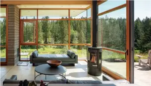  ?? ANDREW POGUE PHOTOS ?? The living room in the Stillwater residence connects with the lush, green surroundin­gs through walls of windows and a concrete floor that reaches from the inside to the outdoor patio.