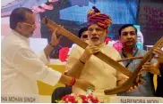  ?? PRITAM BANDYOPADH­YAY ?? Agricultur­e minister Radha Mohan Singh presents a model of a plough to Prime Minister Narendra Modi during the launch of the DD Kisan channel at Vigyan Bhavan in New Delhi on Tuesday. —