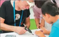  ?? PROVIDED TO CHINA DAILY ?? A foreign maker shows children how to use the laser cutting technology at a week-long national mass innovation and entreprene­urship campaign in Shenzhen in 2016.