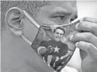  ?? AFP VIA GETTY IMAGES ?? A supporter of Bolsonaro wears a face mask with Bolsonaro’s image during a demonstrat­ion at Copacabana Beach in Brazil on June 7.