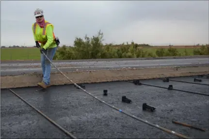  ?? JULIO MORALES PHOTO ?? Ironworker­s Local 229 apprentice Maria Gradilla, of Brawley, arranges three-quarter inch, 28-foot long steel rebar on top of an asphalt base in anticipati­on of concrete paving on a segment of the Interstate 8 Update Project on Dec. 21 near El Centro.