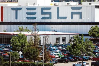  ?? Gabrielle Lurie/The Chronicle ?? A person enters a building at the Tesla car factory on May 11, 2020, in Fremont. Tesla will be laying off thousands of Bay Area employees, according to state filings.