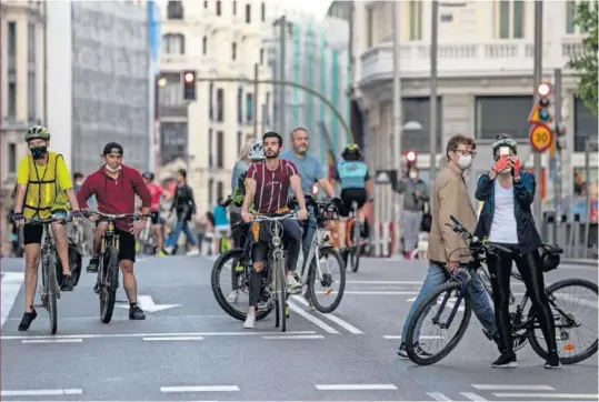  ??  ?? La Gran Vía de Madrid, con ciclistas y paseantes durante las horas permitidas para salir a la calle.