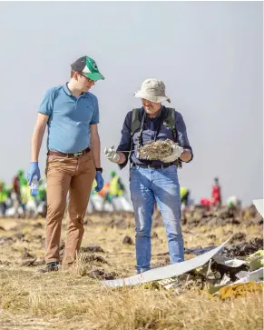  ?? MULUGETA AYENE / THE ASSOCIATED PRESS ?? Investigat­ors examine wreckage at the scene where the Ethiopian Airlines Boeing 737 Max 8 crashed shortly after takeoff on Sunday, killing all 157 on board.