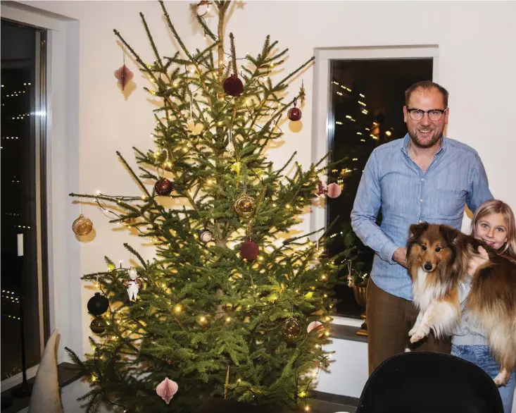  ??  ?? Granen står så grön och grann i huset i Mellbystra­nd. Magnus Haglund ser fram emot en tarditione­ll jul med nära och kära. Här med dottern Ida och hunden Ville medan frun Anna och den andra dottern Ella var iväg och red.