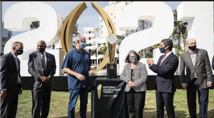  ?? CARL JUSTE cjuste@miamiheral­d.com ?? Mayors Dan Gelber of Miami Beach, third from left; Daniella Levine Cava of Miami-Dade, center; Francis Suarez of Miami, to her left; and Bill Hancock, executive director of the College Football Playoff, right, gather around the National Championsh­ip trophy Thursday in Miami Beach