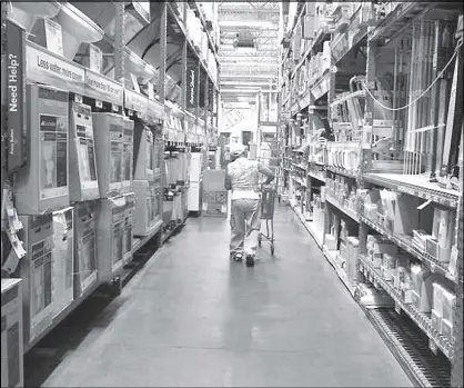  ?? REUTERS ?? A man pushes his shopping cart down an aisle at Home Depot store in New York.