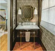  ?? KELLY KISH PHOTOGRAPH­Y ?? A powder room designed by Peter Spalding features Katie Ridder’s Oiseau wallpaper, barn-hued tile, contempora­ry lighting and a sleek marble sink.