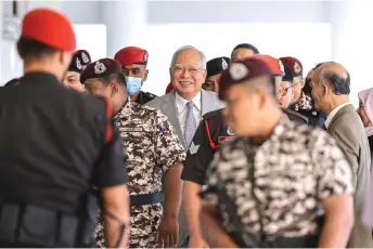  ?? — Bernama photo ?? Najib is seen smiling while being escorted to the courtroom.