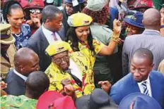  ?? AP ?? Zimbabwe President Robert Mugabe (left) and his wife Grace greet supporters at a solidarity rally in Harare, Wednesday.