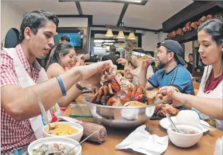  ?? MARIUXI CÁCERES / EXPRESO ?? Guayaquil. Una familia de visita en la ciudad disfruta del cangrejo en el restaurant­e Manny’s, en Miraflores.