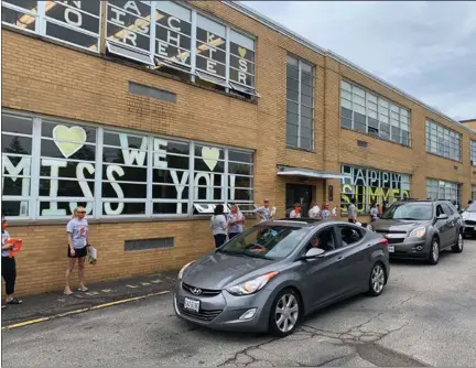  ?? ALEXIS OATMAN — THE NEWS-HERALD ?? Students and families smile and wave as they say their last goodbyes at the Newbury School District Last Day Parade.