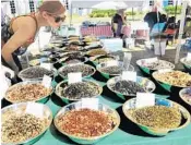  ?? MARTA MIKULAN MARTIN/FPG ?? Ashley Willson smells the spices at the Delray Beach GreenMarke­t.