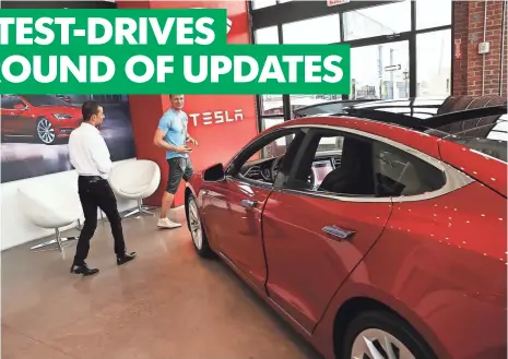  ?? SPENCER PLATT, GETTY IMAGES ?? People check out a Tesla at a showroom in Brooklyn, N.Y., this summer. The update is dubbed Autopilot HW2, or Hardware 2.
