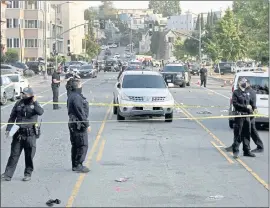  ??  ?? Officers and paramedics respond to a mass shooting on Lakeshore Avenue near Lake Merritt on Saturday. One person was killed and at least six others were wounded in the gunfire.