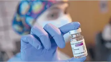  ?? ALVARO BARRIENTOS/AP ?? A health care worker holds a vial containing the AstraZenec­a COVID-19 vaccine in Logrono, Spain.