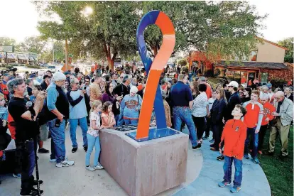  ?? [PHOTO BY BRYAN TERRY, THE OKLAHOMAN] ?? A crowd that includes family members of those who were killed and victims of the 2015 homecoming parade crash at Oklahoma State University looks at the Stillwater Strong Memorial after its unveiling Friday.