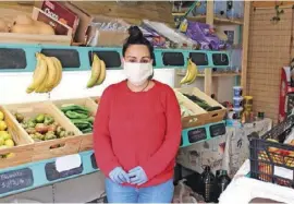  ??  ?? Mit Handschuhe­n und Schutzmask­e: Die Obstverkäu­ferin Rocío Sierra schützt sich und ihre Kunden, so gut sie kann.