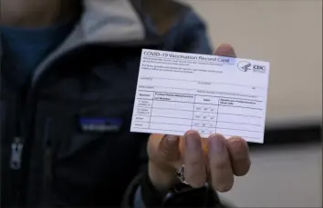  ?? Craig Ruttle/Associated Press ?? A nurse practition­er holds a COVID-19 vaccine card at a New York Health and Hospitals vaccine clinic in the Brooklyn borough of New York on Jan. 10, 2021.