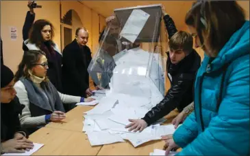  ?? The Associated Press ?? BALLOT BOX: The members of the local election commission open a ballot box for counting at a polling station during the presidenti­al elections on Sunday in St. Petersburg, Russia. With ballots from 80 percent of Russia’s precincts counted by late...