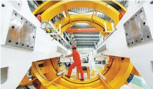  ?? LONG WEI / XINHUA ?? A worker installs parts of a shield machine at a production center in Hangzhou, Zhejiang province.