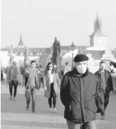  ?? PETR DAVID JOSEK/AP ?? The Czech Republic last week had a record 8,500 people hospitaliz­ed with COVID-19. Above, a man walks across the Charles Bridge on Feb. 25 in Prague.