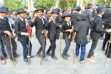  ?? — AFP ?? Young Charlie Chaplin impersonat­ors pose for a picture during an event commemorat­ing the legendary actor’s 129th birthday in Adipur, some 60 km northwest of Bhuj in the western Indian state of Gujarat, on Monday.