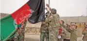  ?? (AFP) ?? US soldiers and Afghan personnel raise Afghanista­n’s national flag during a handover ceremony, at Antonik camp in Helmand province