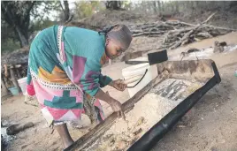  ??  ?? EARLY BIRD. Phephu Mchavi, 62, scratches salt from a metal pan early in the morning on the bank of the Klein Letaba River near Baleni in Limpopo.