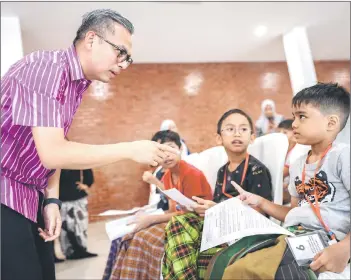  ?? — Bernama photo ?? Communicat­ions Minister Fahmi Fadzil share a light moment with children at the Lembah Pantai Parliament Khatan ceremony at Masjid Al-Khadijah in Pantai Dalam yesterday.