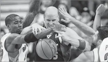  ??  ?? Raptors forward Ed Davis (left) battles for the loose ball against Mavericks forward Chris Kaman (center) for a loose ball on Friday. Kaman scored 15 points, but called the loss ‘frustratin­g.’