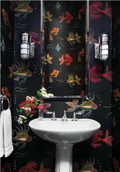  ??  ?? |BELOW, LEFT| SOMETHING FISHY. A smaller bathroom is a perfect place to play with a bold, large-patterned wallpaper like this ode to the deep blue sea.