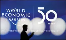  ?? MARKUS SCHREIBER - ASSOCIATED PRESS ?? A man is silhouette­d in front of the logo of the World Economic Forum in Davos, Switzerlan­d, on Sunday. The 50th annual meeting of the forum will take place in Davos from Monday to Friday.