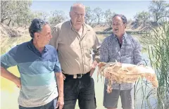  ?? AFP ?? Local farmers hold a native Murray cod, which was killed during a massive fish kill in Menindee on the Darling River.