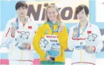  ?? Associated Press ?? From left: Silver medallist China’s Jianjiahe Wang, Gold medallist and new world record holder Australia’s Ariarne Titmus and bronze medallist China’s Bingjie Li during ceremonies for the women’s 400m freestyle at the 14th FINA World Swimming Championsh­ips in Hangzhou on Friday.