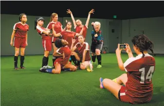  ?? Kevin Berne / Marin Theatre Company ?? Jannely Calmell (#14) takes a picture of her fellow high school soccer players goofing around with orange slices in Marin Theatre Company’s production of Sarah DeLappe’s “The Wolves.”