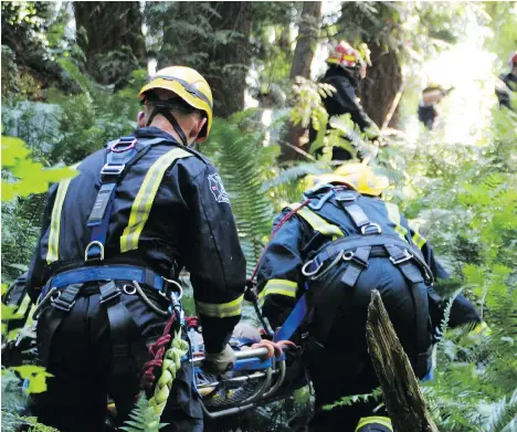  ?? SHANE MacKICHAN ?? Surrey firefighte­rs perform a rescue on Tuesday in a steep ravine along Delta Creek, near 97th Avenue and 117B Street. A woman, suffering non-life-threatenin­g injuries, was found calling out for help in the afternoon. The woman, who was taken to...