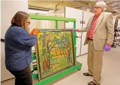  ??  ?? Photo shows Karen Papineau, left, and Kurt Sundstrom look at the other side of a painting by German artist Max Pechstein, in Manchester, NH. — AP